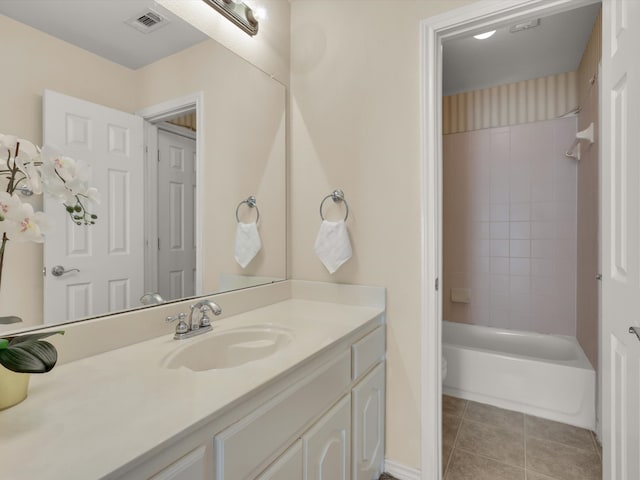 bathroom with tiled shower / bath, vanity, and tile patterned flooring