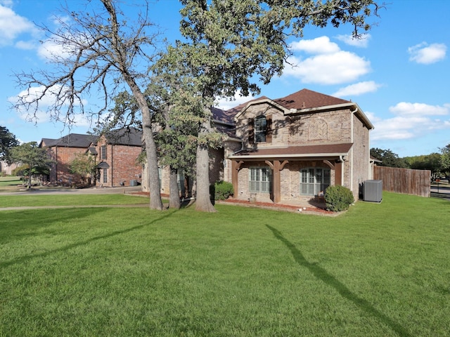 rear view of property featuring central AC unit and a yard