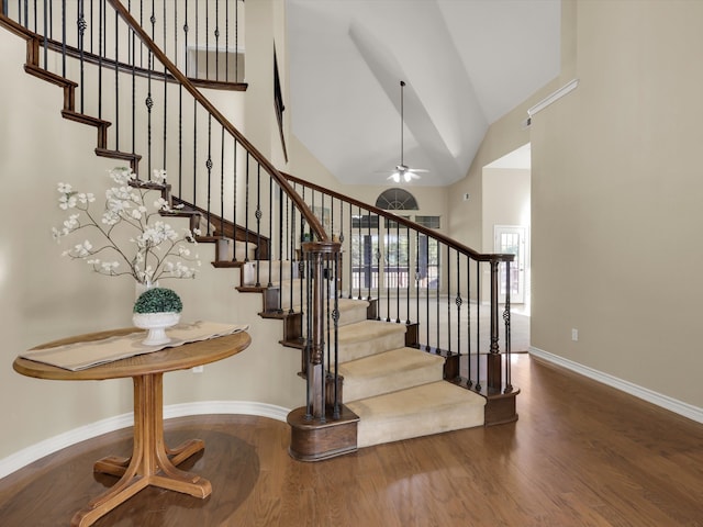 staircase with high vaulted ceiling and hardwood / wood-style flooring