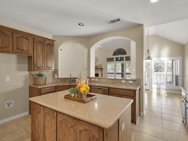 kitchen featuring light stone countertops, light tile patterned floors, hanging light fixtures, dishwasher, and vaulted ceiling