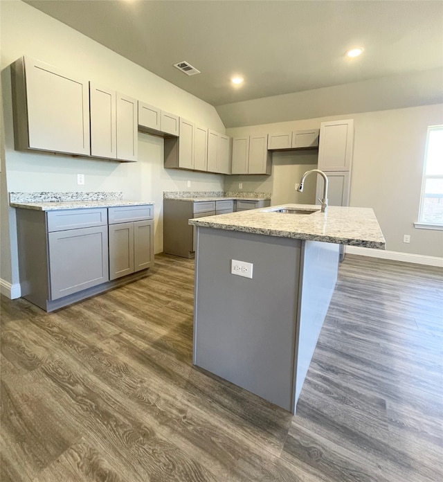 kitchen featuring a kitchen island with sink, dark hardwood / wood-style flooring, sink, and gray cabinetry