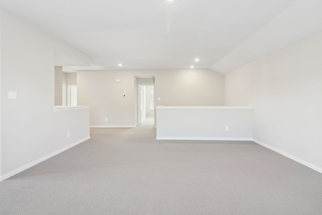 carpeted spare room featuring lofted ceiling