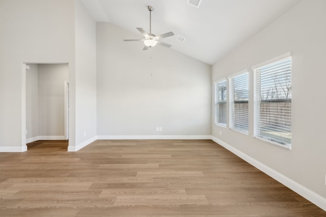 spare room featuring light hardwood / wood-style floors, high vaulted ceiling, and ceiling fan