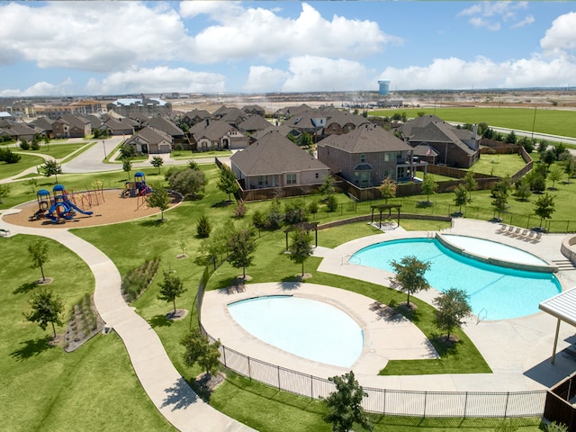 view of swimming pool featuring a hot tub, a playground, a lawn, and a patio area