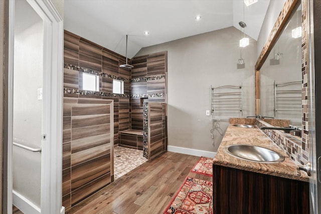 bathroom featuring a shower, vanity, vaulted ceiling, and hardwood / wood-style flooring