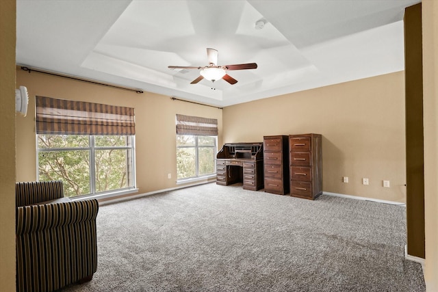 unfurnished room with carpet flooring, a raised ceiling, and ceiling fan