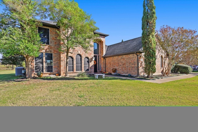 view of front of home featuring cooling unit and a front lawn