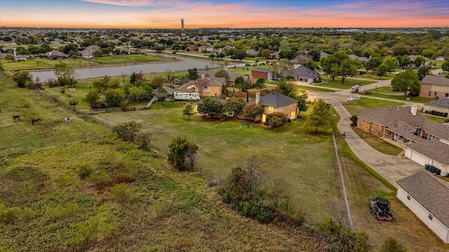 aerial view at dusk featuring a water view