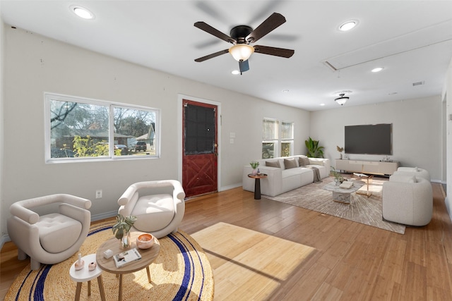 living room featuring hardwood / wood-style floors and ceiling fan