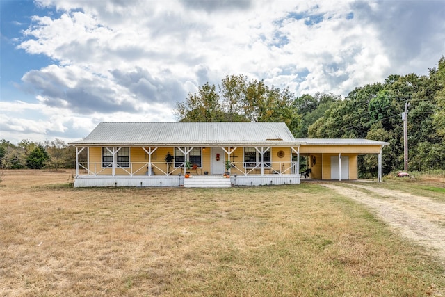 1345 Fm 1563, Wolfe City, TX 75496 - farmhouse featuring a porch, driveway, a front lawn, and metal roof