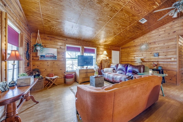 living room with wooden ceiling, ceiling fan, lofted ceiling, wooden walls, and light wood-type flooring