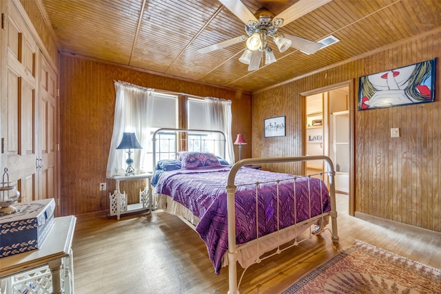 bedroom featuring wood walls, wooden ceiling, ceiling fan, and wood-type flooring