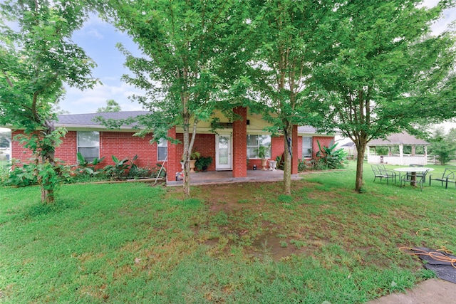 view of front of house with a front yard and a patio area