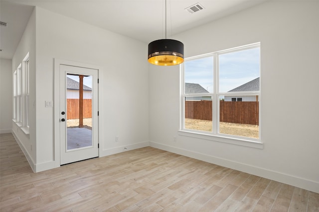 unfurnished dining area featuring a wealth of natural light and light wood-type flooring