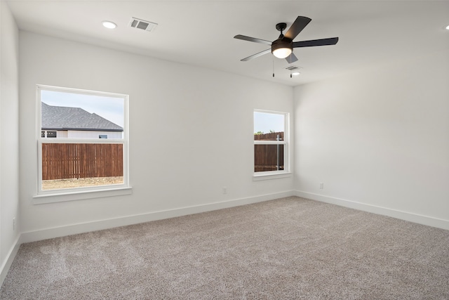 unfurnished room with ceiling fan, a healthy amount of sunlight, and carpet floors