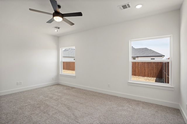 empty room featuring a wealth of natural light, ceiling fan, and carpet floors