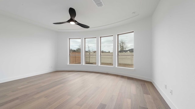 spare room with light wood finished floors, visible vents, baseboards, and a ceiling fan