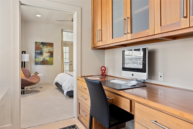 carpeted home office with built in desk