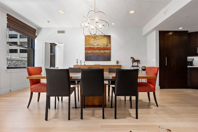 dining space featuring light hardwood / wood-style floors and a chandelier