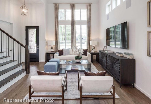 living room featuring hardwood / wood-style flooring, a high ceiling, and a notable chandelier