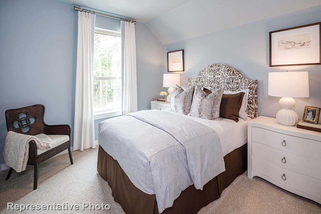 bedroom with light colored carpet and lofted ceiling