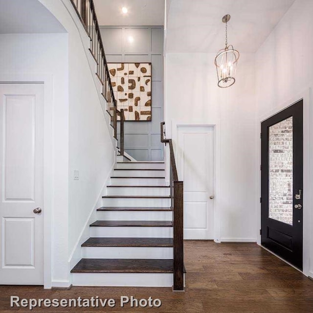 entryway with dark hardwood / wood-style floors and a chandelier