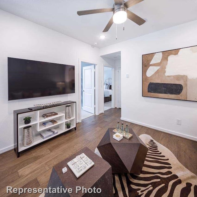 living room featuring ceiling fan and dark hardwood / wood-style flooring