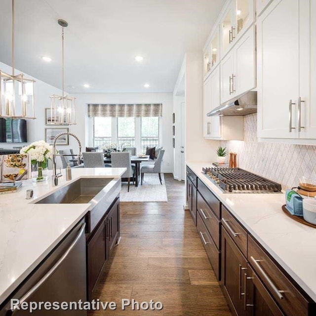 kitchen with white cabinetry, sink, appliances with stainless steel finishes, dark hardwood / wood-style floors, and decorative light fixtures