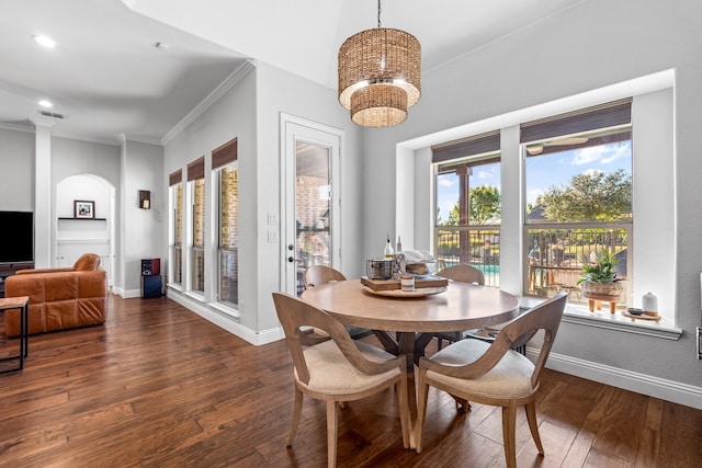 dining space with an inviting chandelier, dark wood-type flooring, and ornamental molding