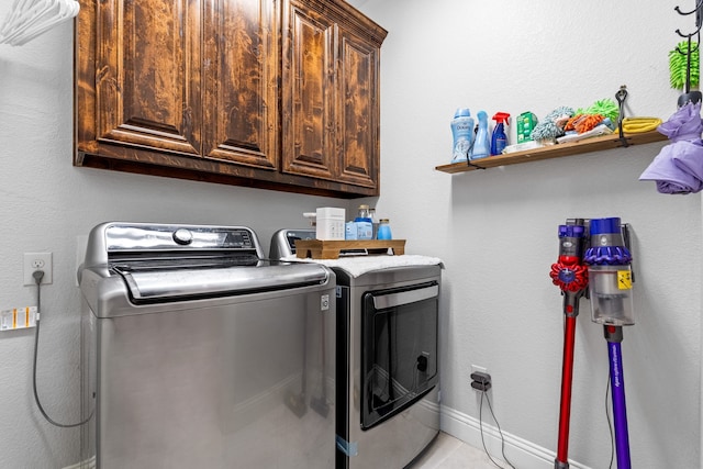 washroom featuring washer and dryer and cabinets