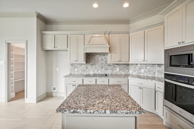 kitchen with a center island, light stone countertops, and appliances with stainless steel finishes