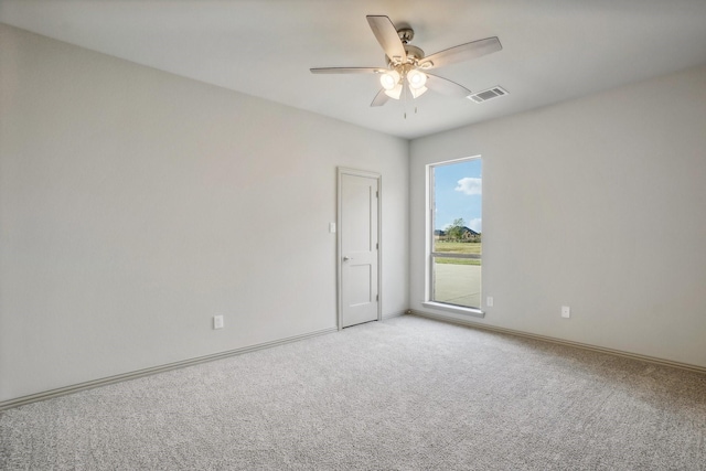 empty room featuring light colored carpet and ceiling fan