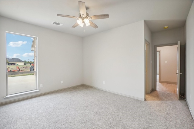 carpeted spare room with ceiling fan