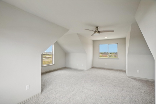 additional living space with ceiling fan, light colored carpet, and vaulted ceiling