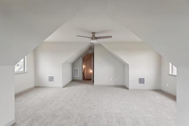 additional living space featuring ceiling fan, light carpet, and vaulted ceiling