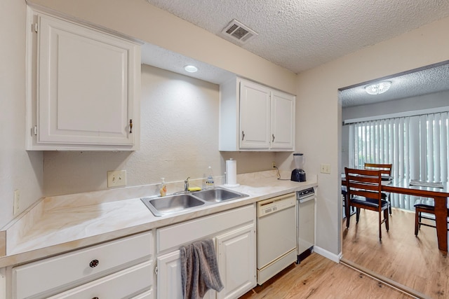 kitchen featuring white cabinetry, light hardwood / wood-style flooring, sink, and white dishwasher