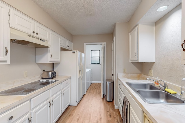 kitchen with white cabinetry, separate washer and dryer, and electric stovetop