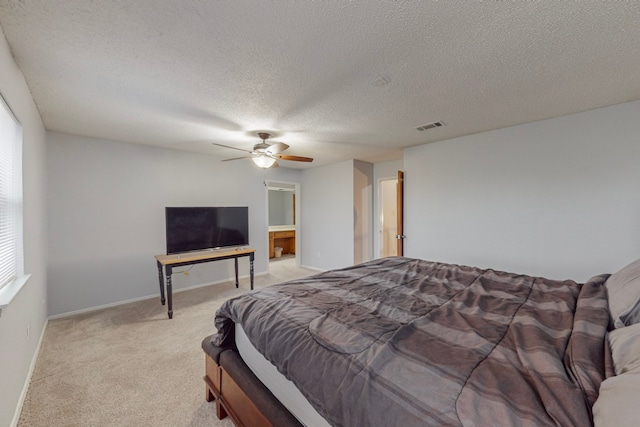 bedroom with a textured ceiling, multiple windows, light colored carpet, and ceiling fan