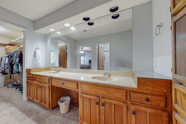 bathroom featuring vanity, a textured ceiling, and ceiling fan