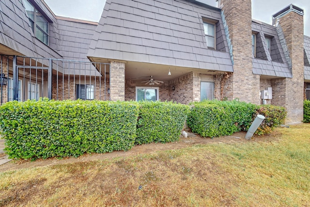 view of home's exterior with ceiling fan and a yard