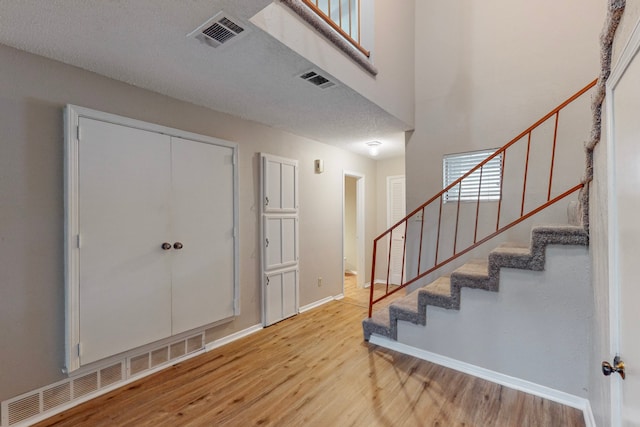 entryway with a textured ceiling and light wood-type flooring