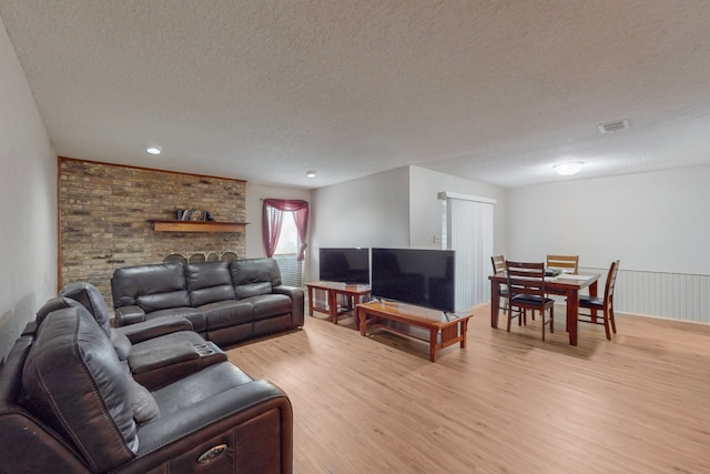 living room featuring light hardwood / wood-style flooring and a textured ceiling