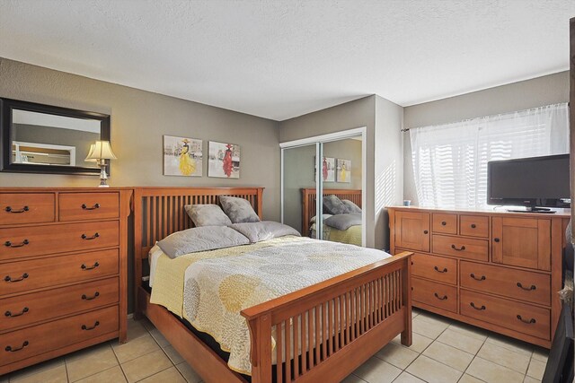 tiled bedroom featuring a textured ceiling and a closet