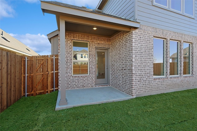 doorway to property with a lawn and a patio