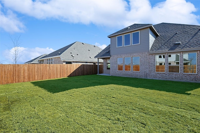 rear view of house featuring a yard