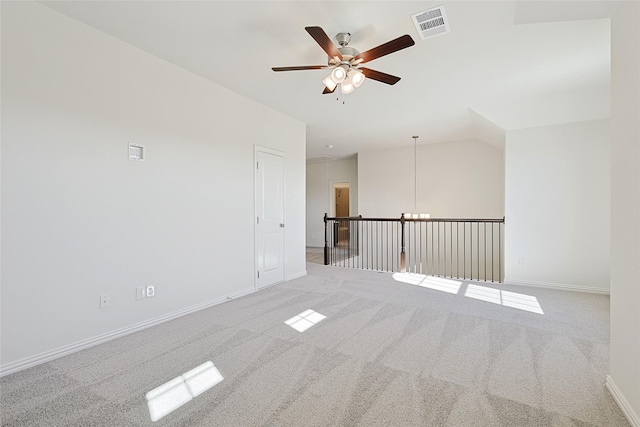 empty room with vaulted ceiling, ceiling fan, and light carpet