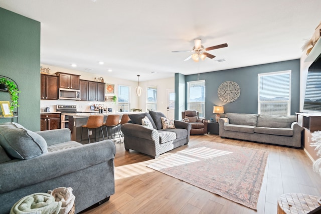 living room featuring ceiling fan and light hardwood / wood-style floors