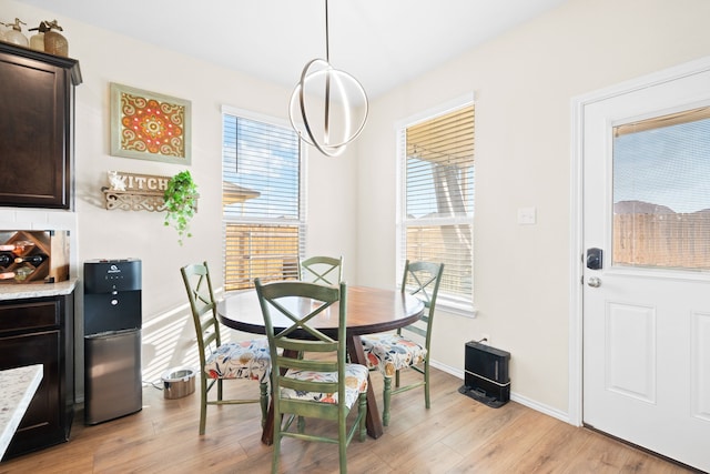 dining room with a healthy amount of sunlight, light hardwood / wood-style floors, and a chandelier