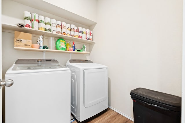 clothes washing area with light wood-type flooring and independent washer and dryer