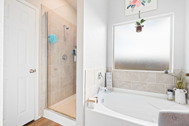 bathroom featuring plus walk in shower and wood-type flooring